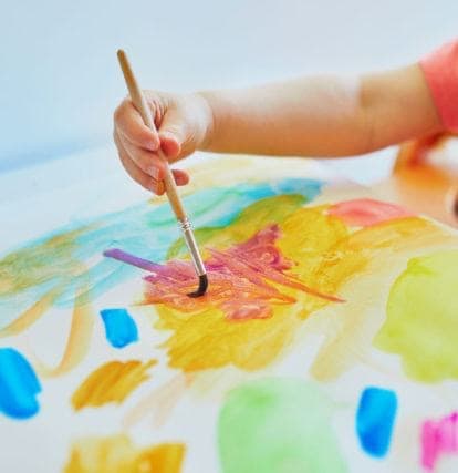Preschool child painting at Brown Bear Day Care